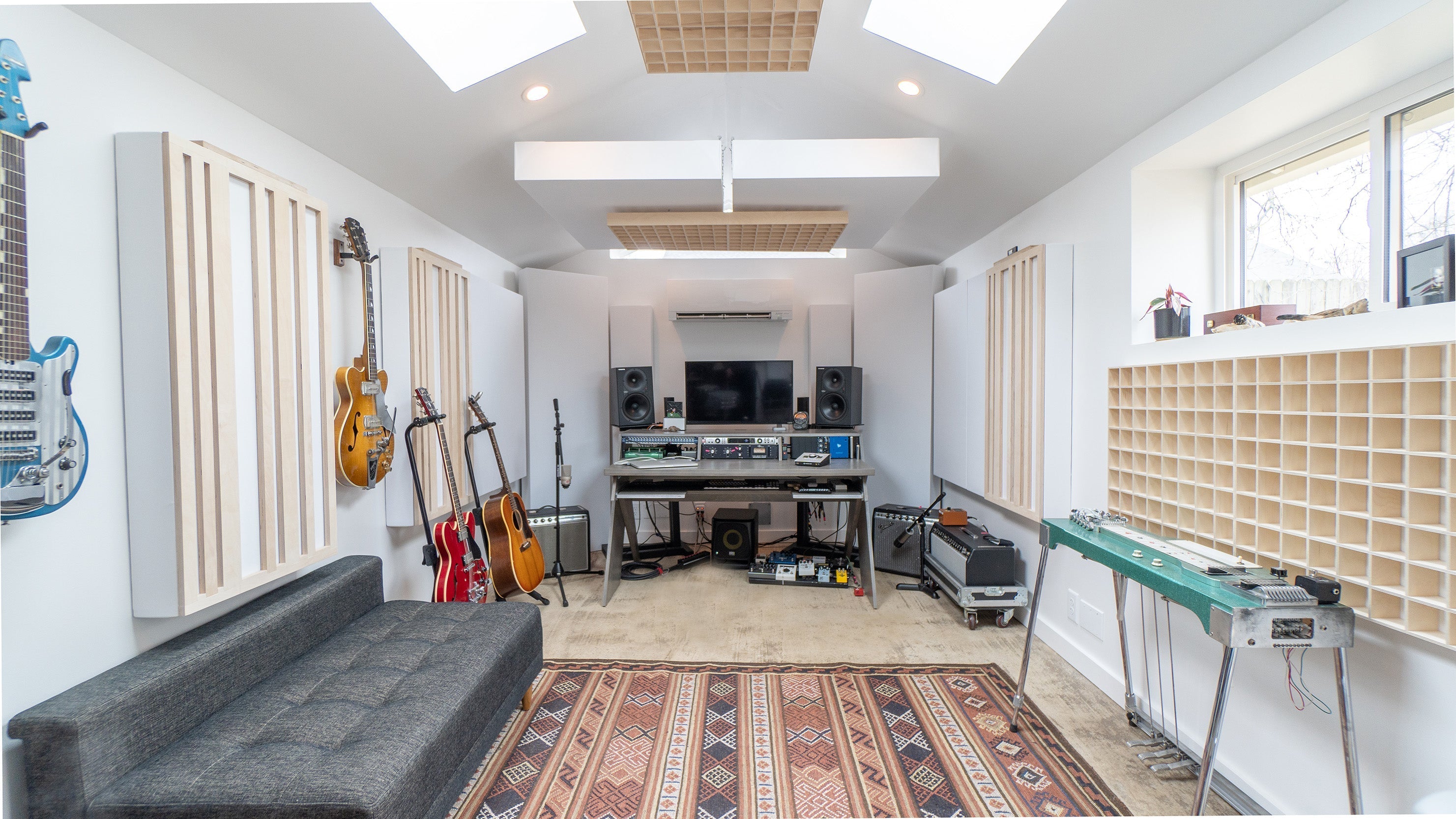 acoustic panels and diffusers in a clean, modern studio with guitars, amplifiers and speakers.