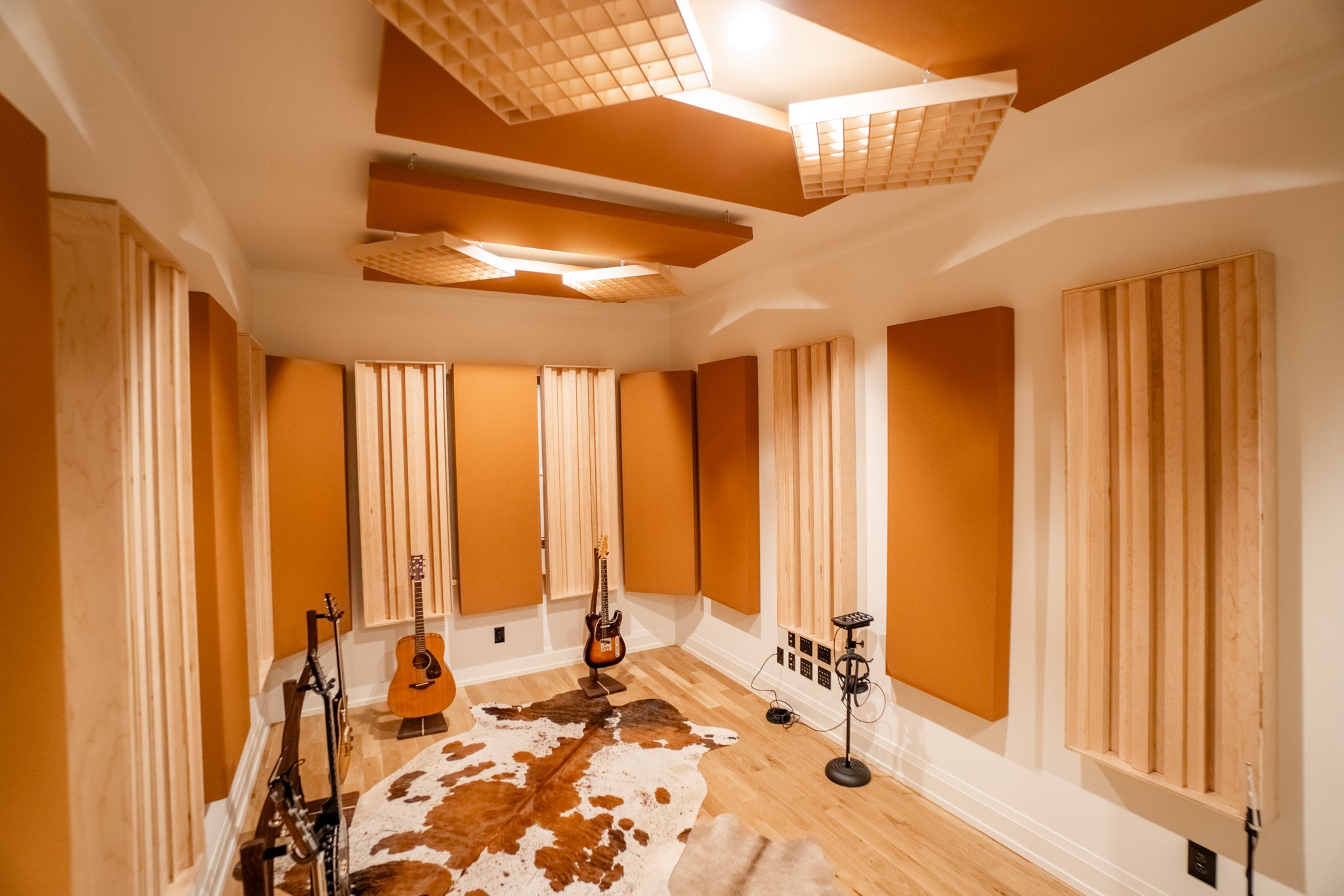 Music studio with Music City Acoustics acoustic panels and diffusers, guitars, and a cowhide rug.